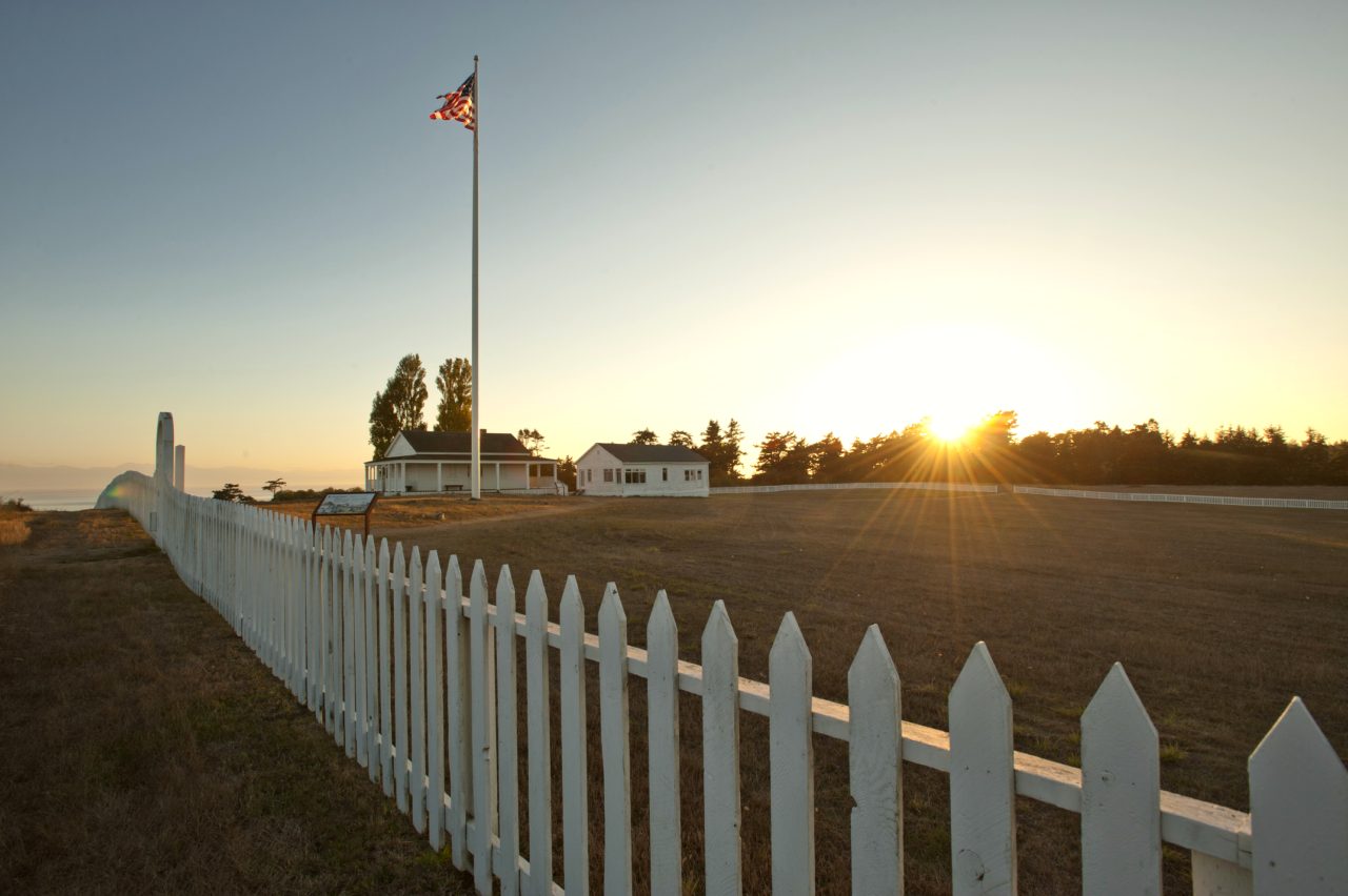 a sun setting behind historic parade grounds