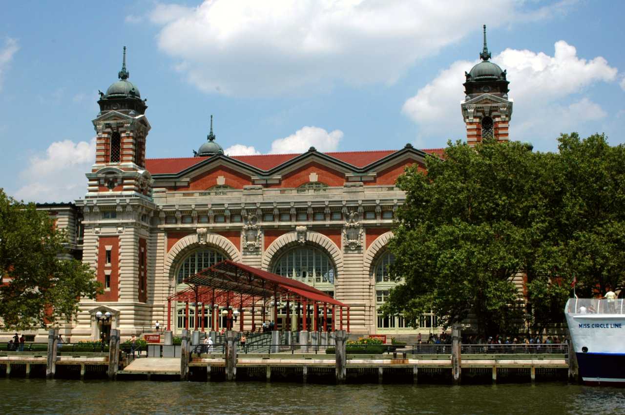 Beaux-Arts brick and limestone building with large arched windows and cupola-topped towers.