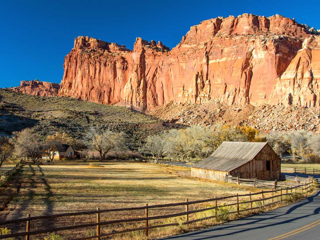 Wingate Sandstone cliffs behind historic barn and farmhouse
