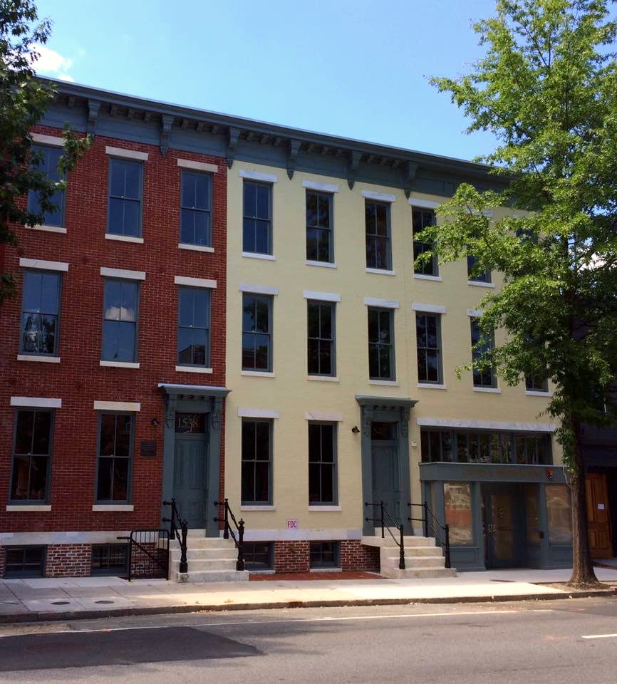 The restored facades of three historic Victorian row-homes on an urban street in Washington, DC