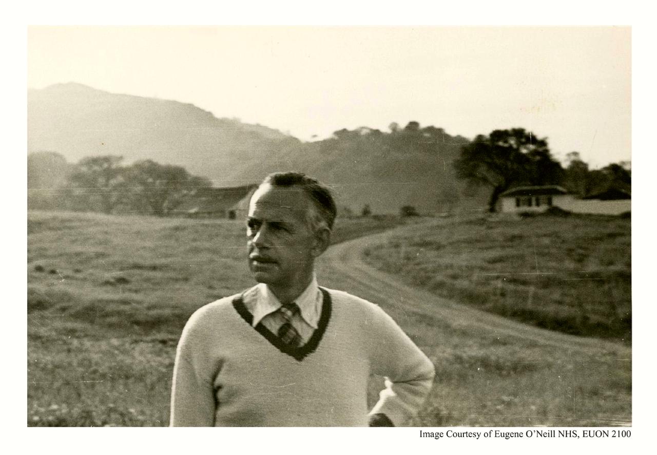 Eugene O'Neill, and older man, poses outside against a hilly background.