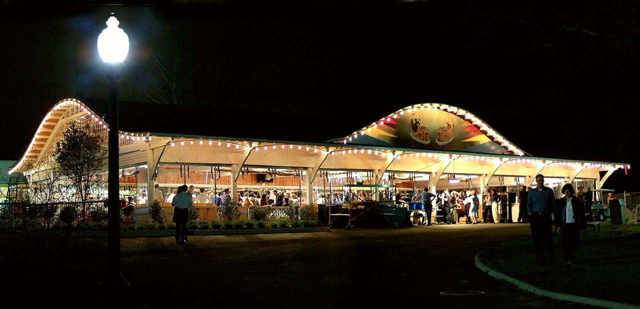 outdoor scene of open dance pavilion illuminated and evening dance crowd inside.