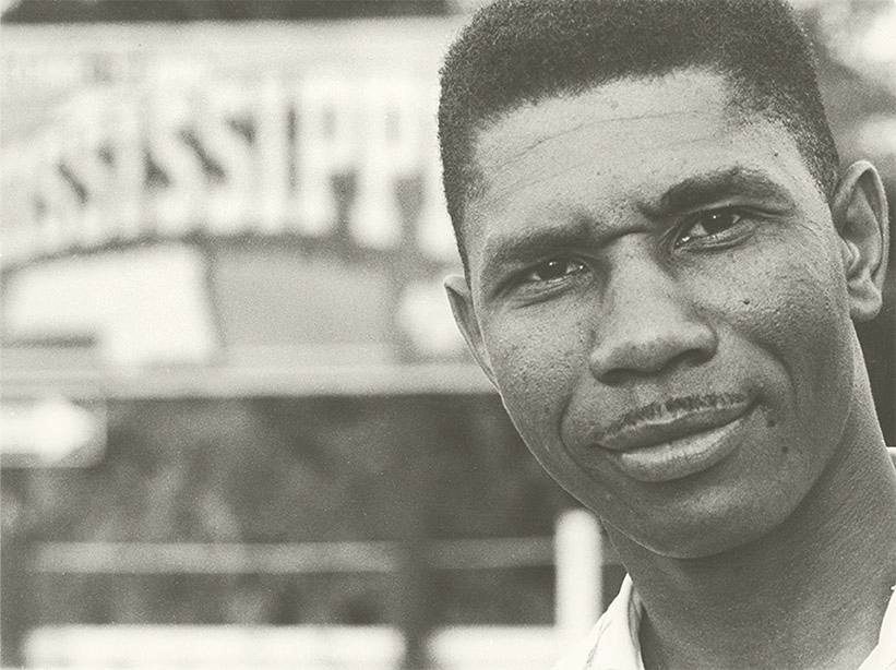 Close up black and white portrait of a black man with a thin mustache