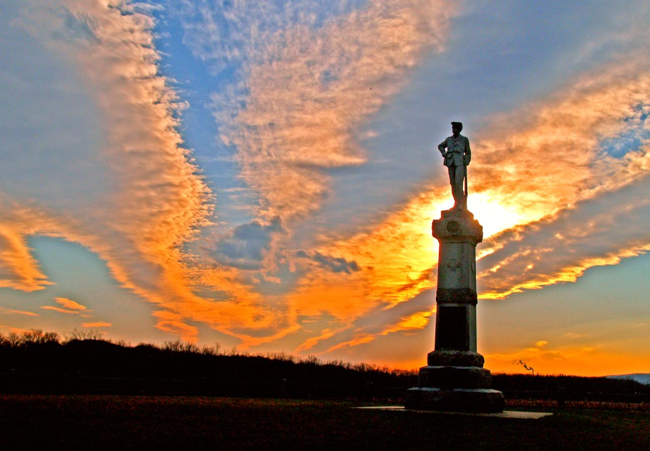 The sun setting behind a monument.