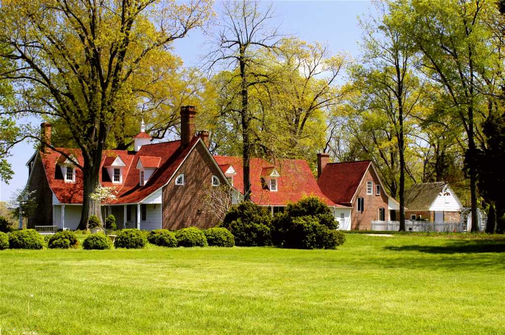 Image of a large historic house with green lawn in foreground.