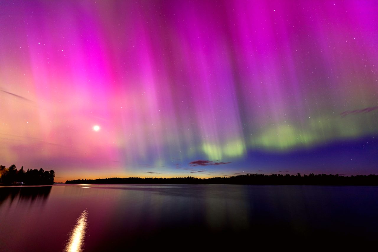 Photograph of northern lights over a lake.