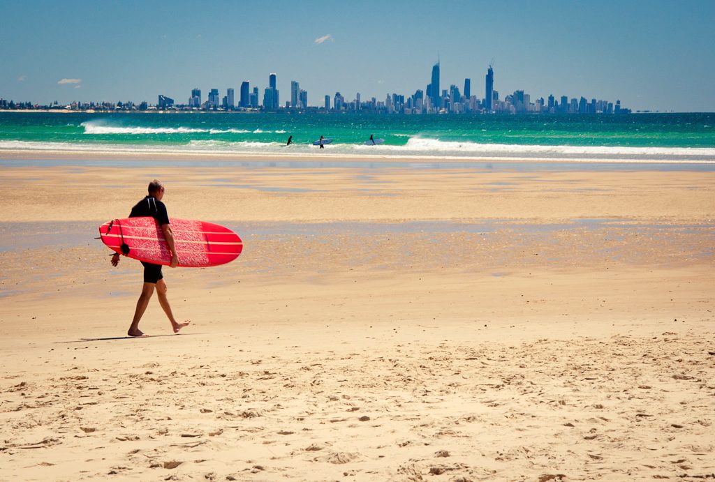 A surfer on the Gold Coast, Queensland. An iconic global image of Australian tourism focuses on its beaches, which are an integral part of the Australian identity.[1]