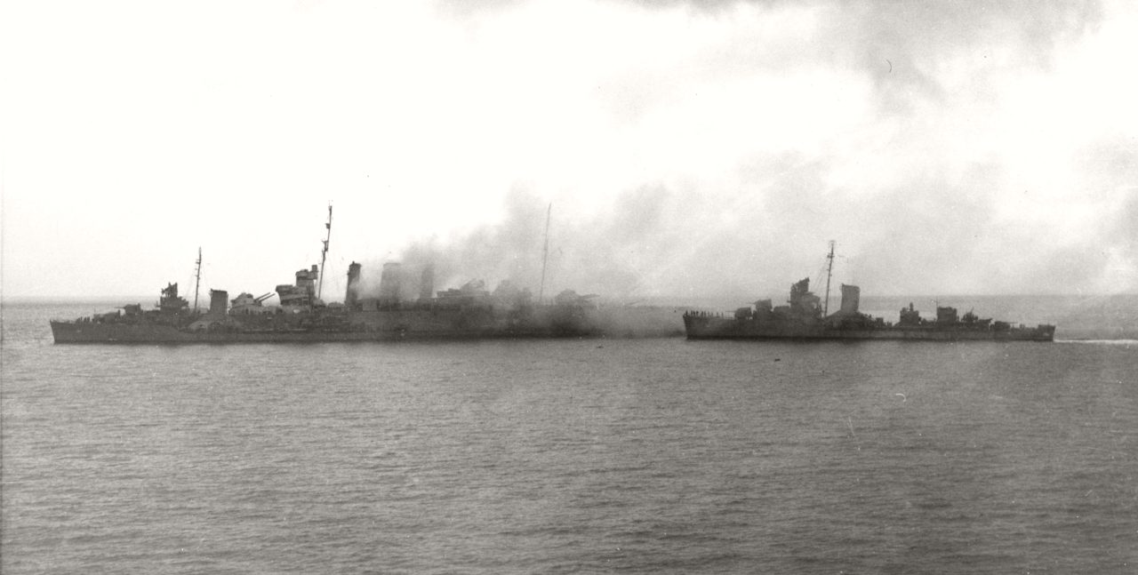 Destroyers removing crew from HMAS Canberra after the Battle of Savo Island, 9 August 1942. USS Blue is alongside Canberra's port bow, as USS Patterson approaches from astern.
